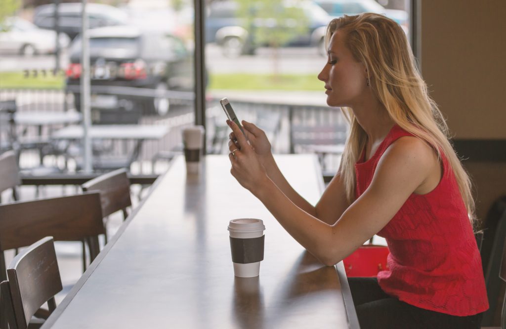 Woman on phone will coffee